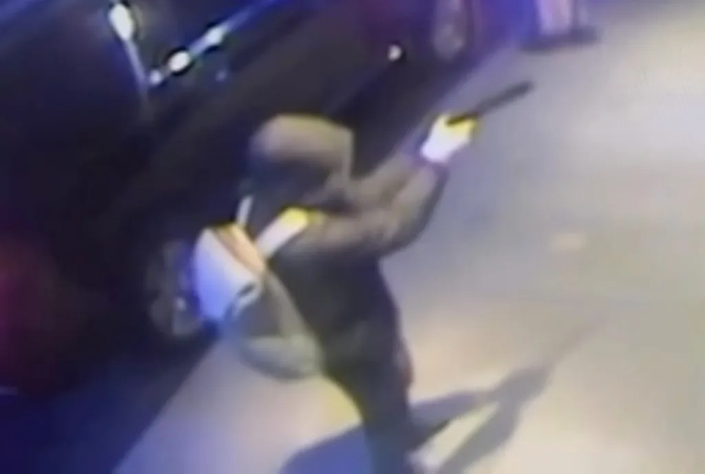 Surveillance footage of Luigi Mangione holding a gun outside the Midtown Hilton Hotel.