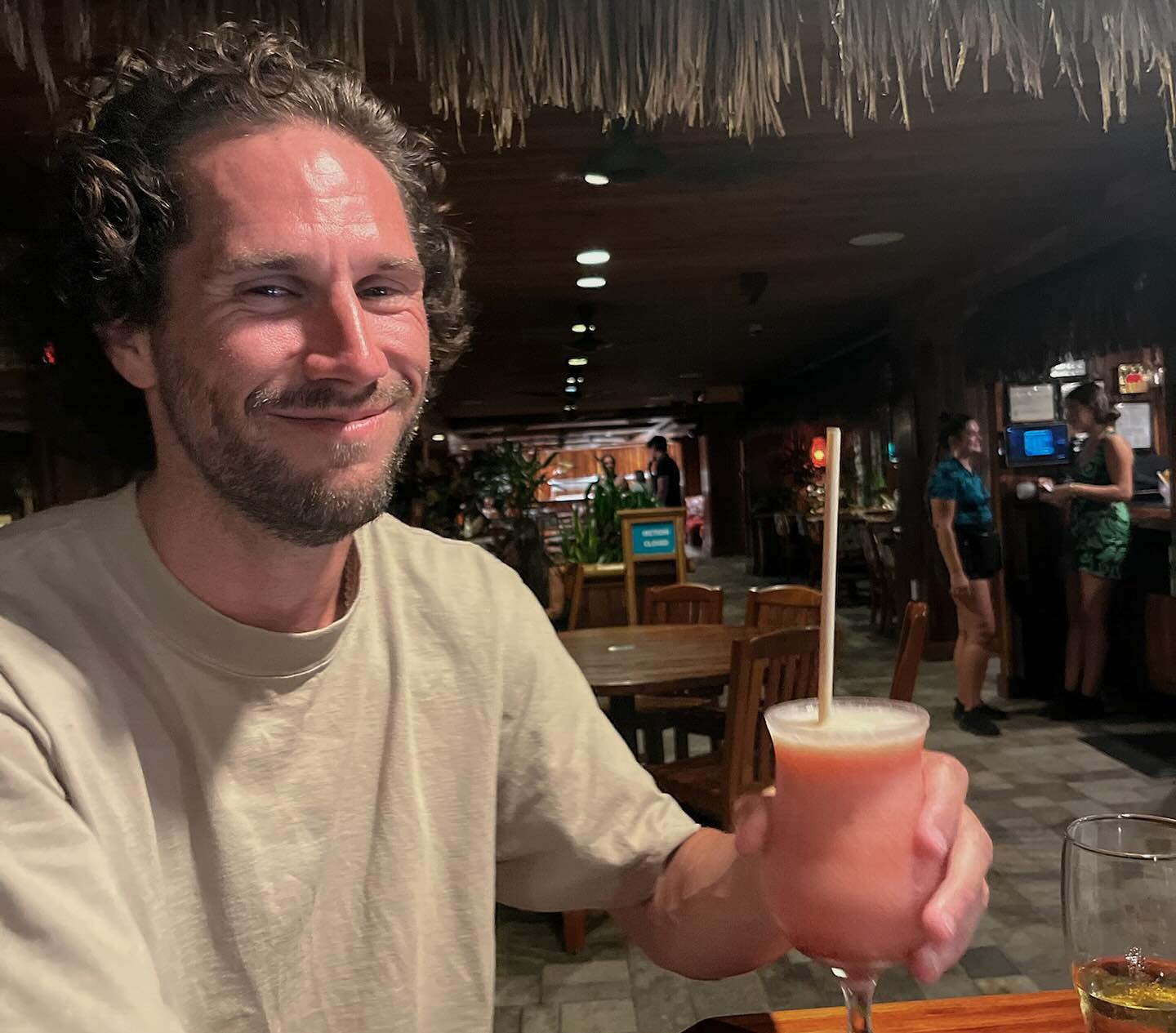 PJ Conley holding a pink drink with a straw.