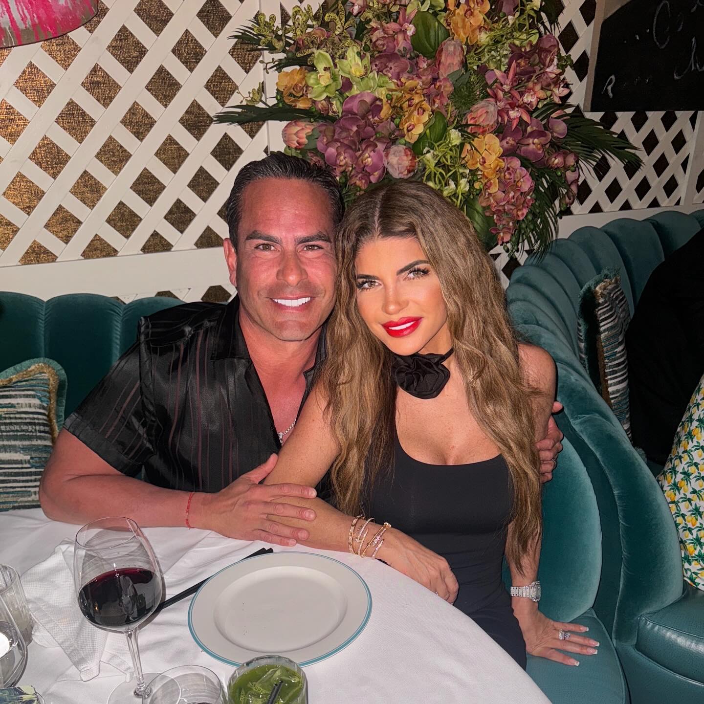 Teresa Giudice and Louie Ruelas smiling at a restaurant.