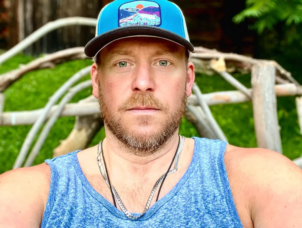 Tyler Duckworth wearing a blue hat and blue tank top