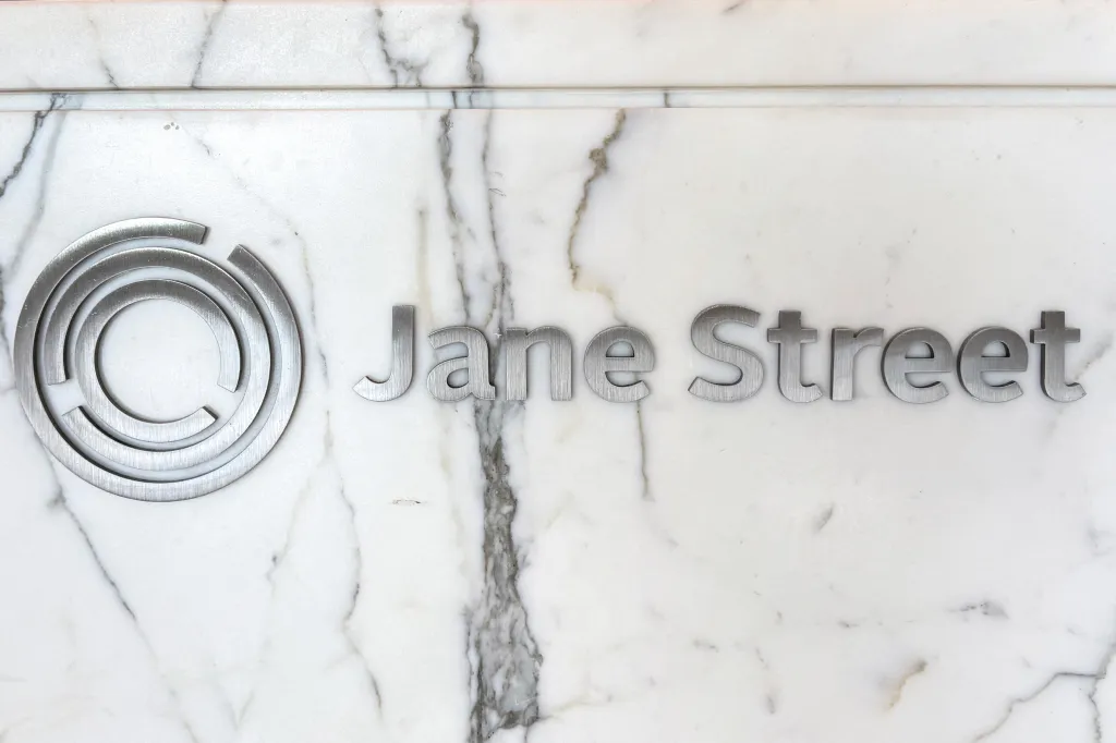 The Jane Street logo and company name in brushed metal on a white marble wall.