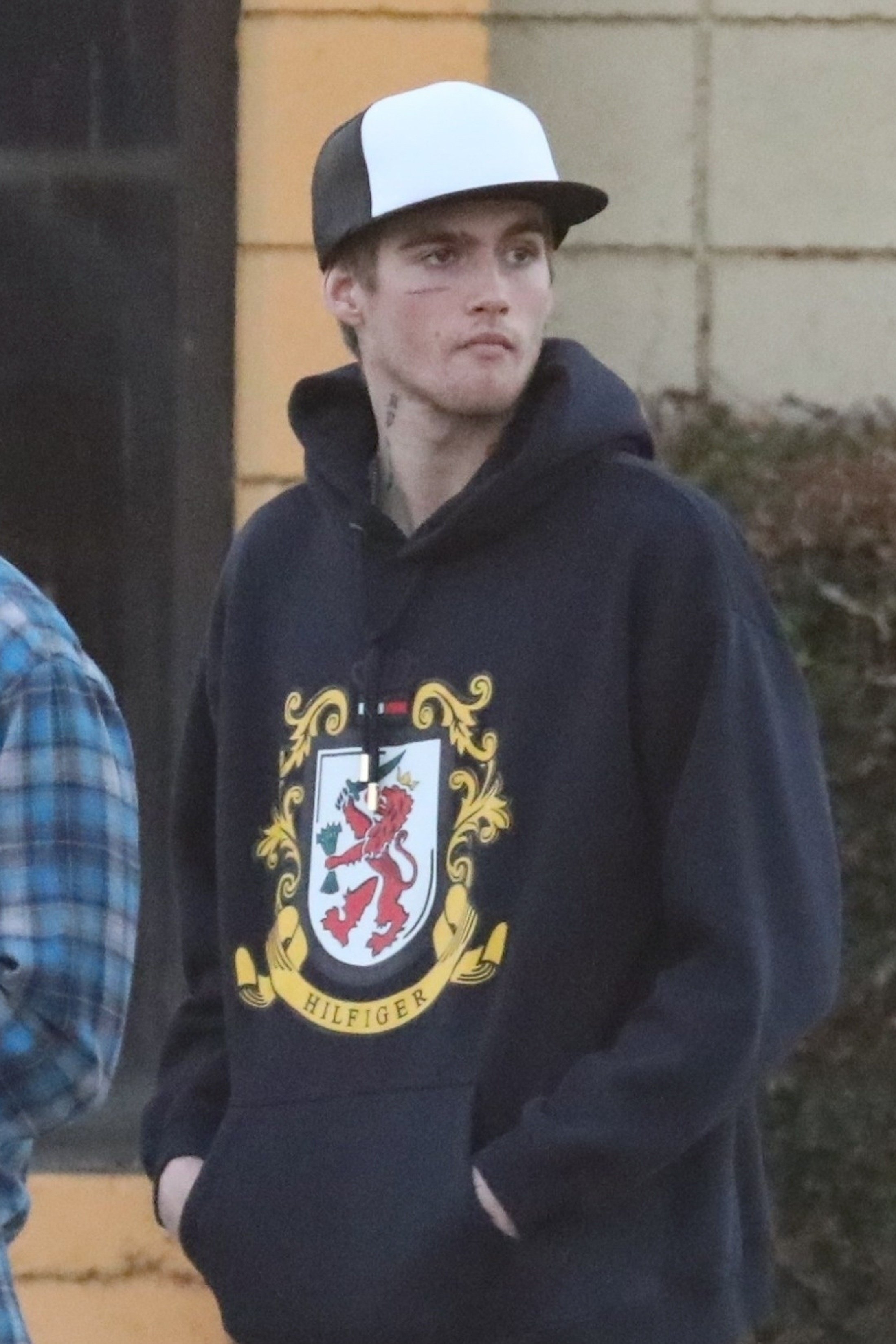 Presley Gerber wearing a navy Tommy Hilfiger hoodie and a black and white baseball cap.