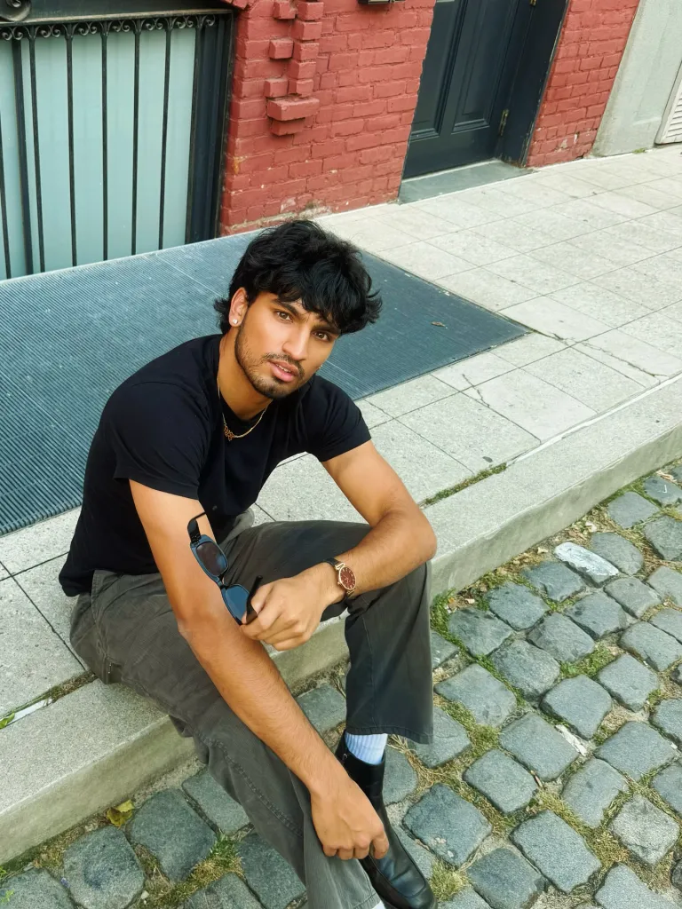 Jasik Dhillon sitting on a curb.
