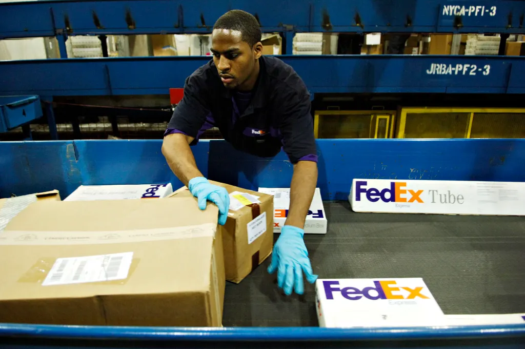 William Moore sorts packages at a FedEx facility.