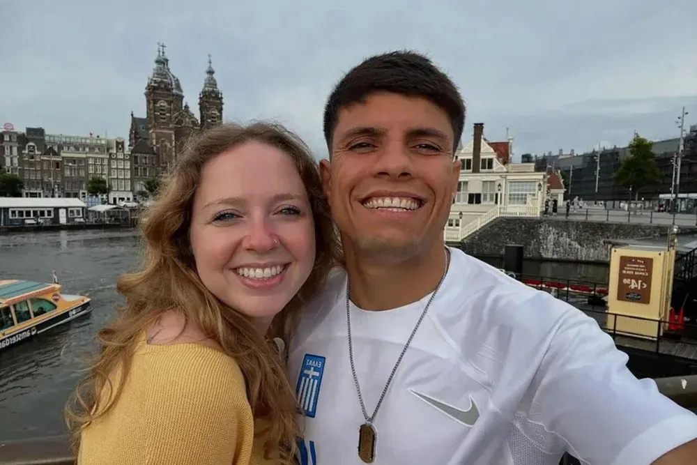 Sharif Ahmadzai and Alaina Hall, smiling for a selfie with a canal and buildings in the background.