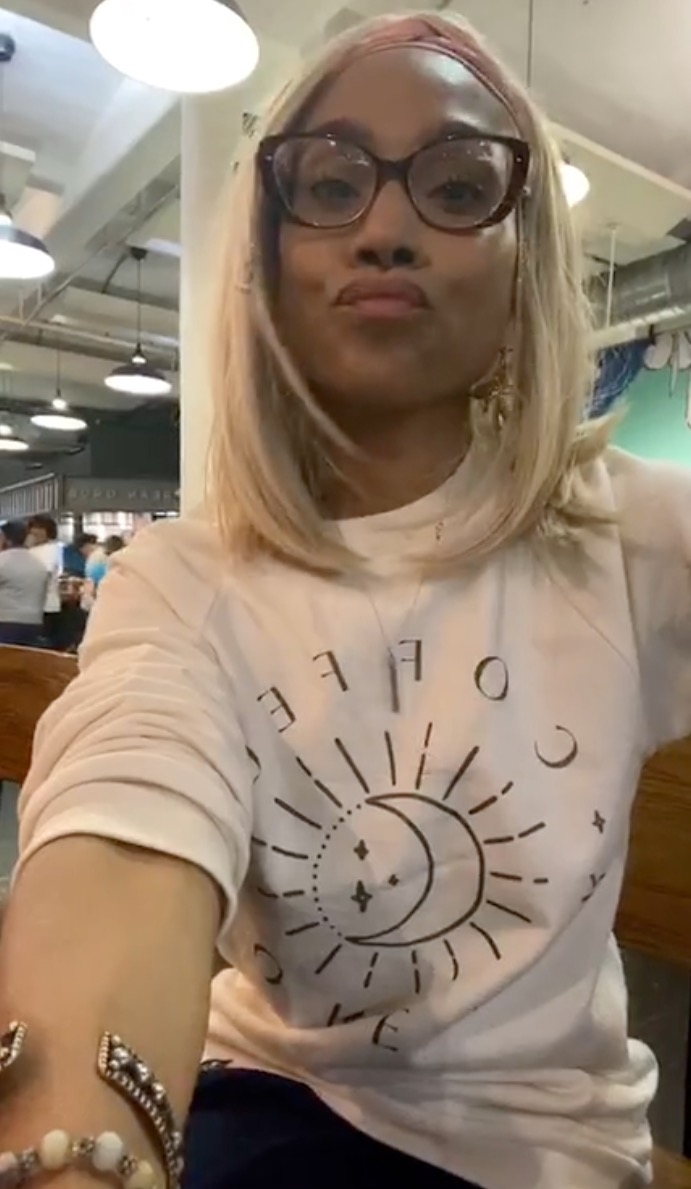Christy Knowings wearing a light-colored long-sleeved shirt with a sun and moon design.