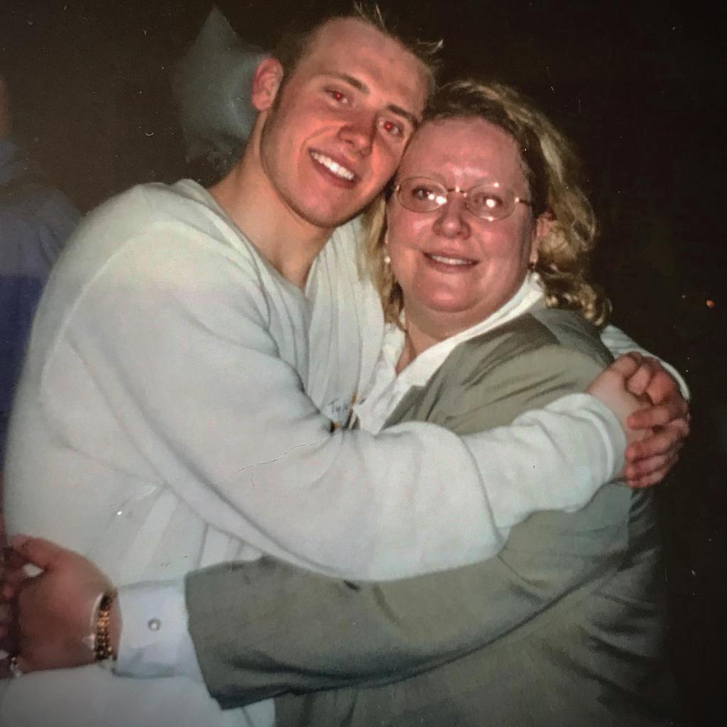 Tyler Duckworth with his mom, Joni, embracing and smiling.