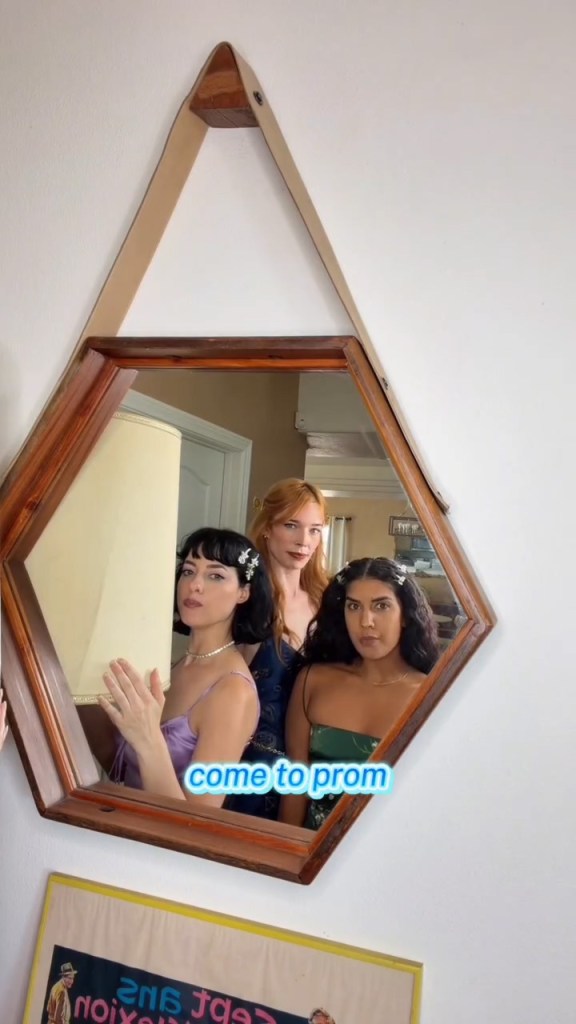 Three women reflected in a hexagonal mirror, with a blue text overlay "come to prom."