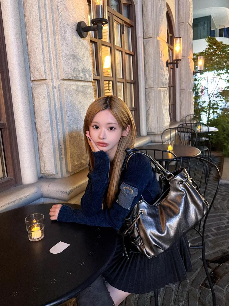 K-pop influencer Mina Chan seated at an outdoor cafe.