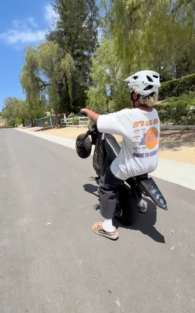 Saint West on a bike popping a wheelie.