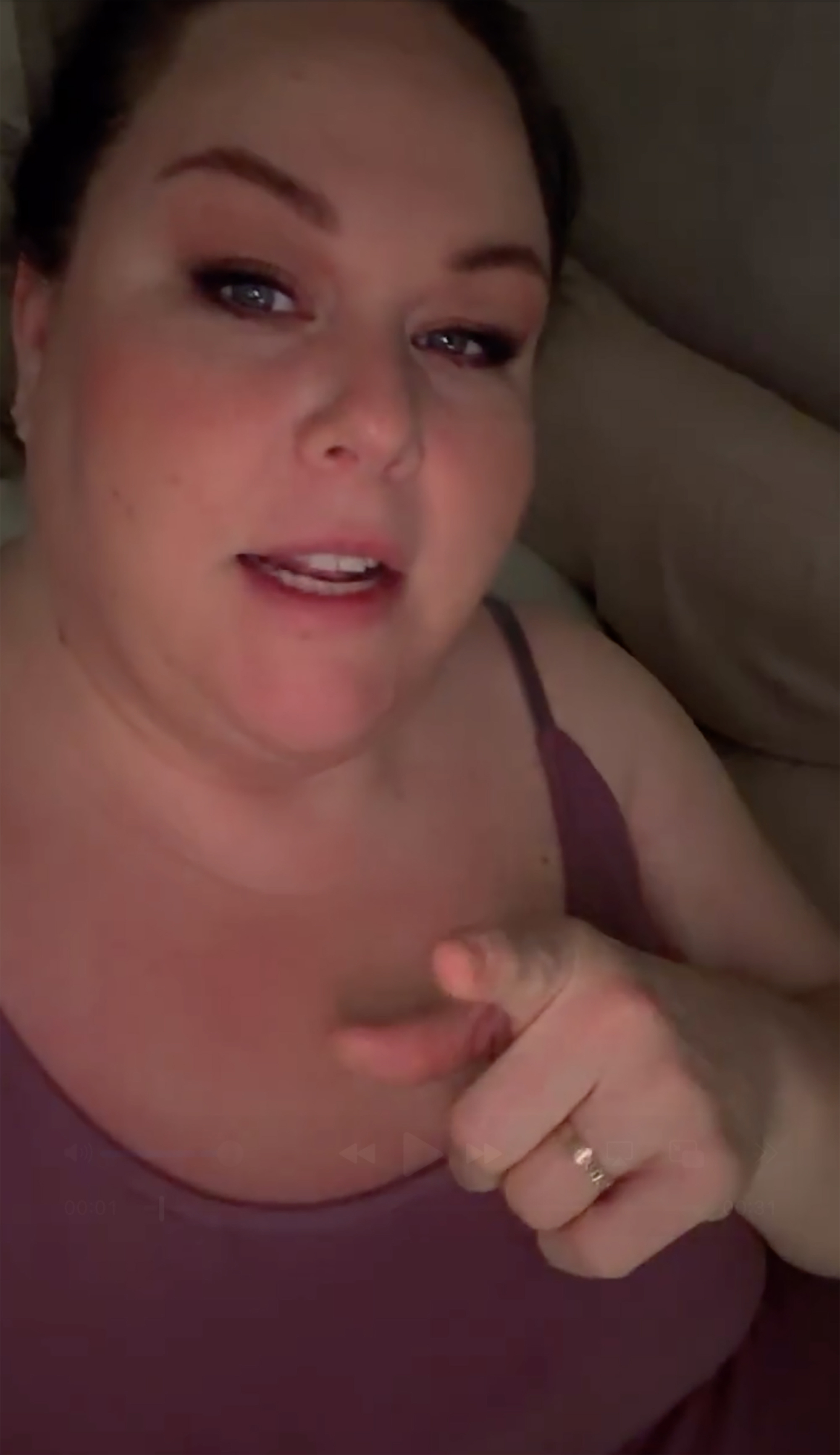 Chrissy Metz in a purple top points towards the camera.