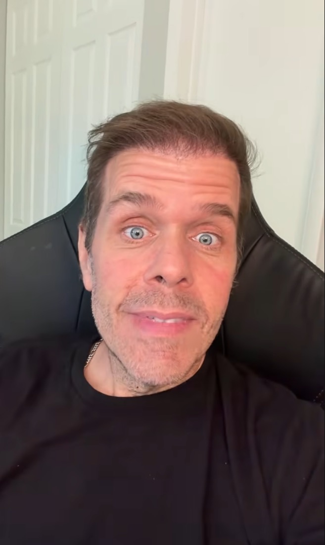 Perez Hilton making a video in a black t-shirt.